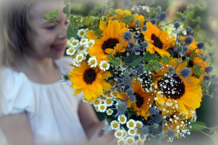Child holding a sunflower bouquet