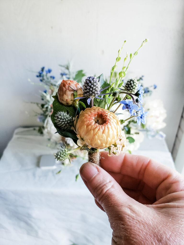 A tiny spring boutonniere with strawflower and other small spring flowers.r